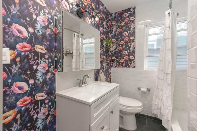 full bathroom with tile walls, curtained shower, toilet, vanity, and tile patterned floors