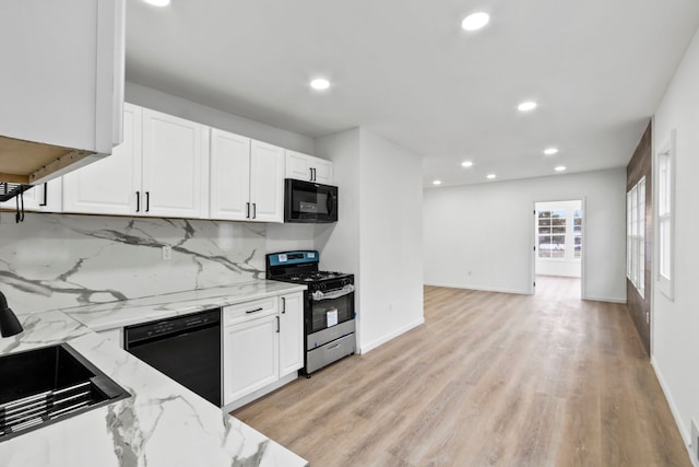 kitchen with black appliances, decorative backsplash, white cabinets, and light stone countertops