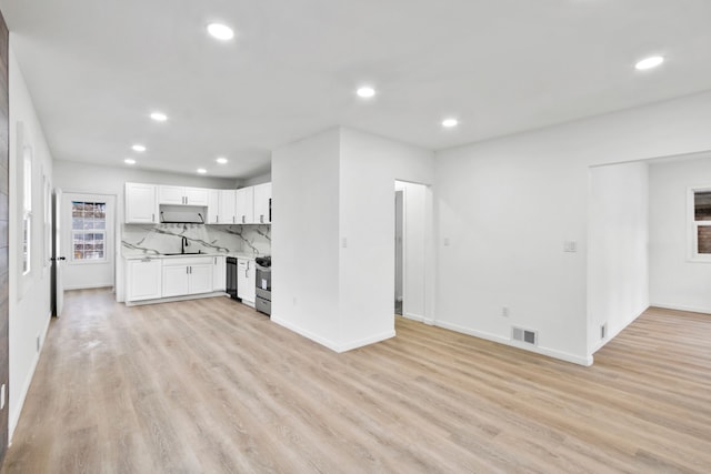 unfurnished living room featuring recessed lighting, visible vents, a sink, and light wood-style flooring