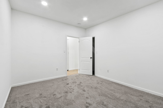 carpeted empty room featuring baseboards and recessed lighting