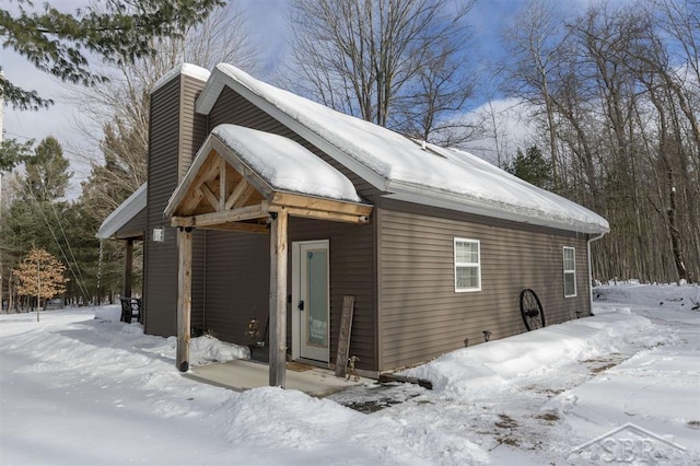 view of snow covered exterior featuring a chimney