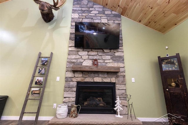 living room with a fireplace, lofted ceiling, wood finished floors, wooden ceiling, and baseboards