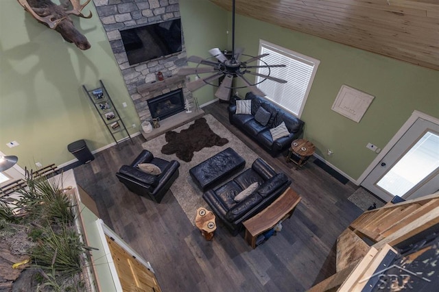 unfurnished living room with baseboards, a ceiling fan, wooden ceiling, dark wood-style flooring, and a fireplace