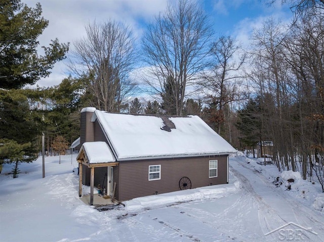 view of snowy exterior featuring a chimney