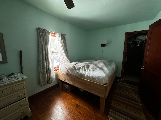 bedroom featuring dark wood-style floors, a closet, and a ceiling fan