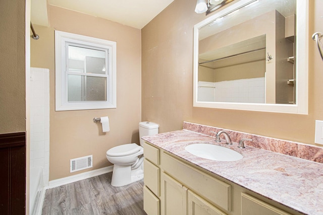 full bathroom with baseboards, visible vents, toilet, wood finished floors, and vanity