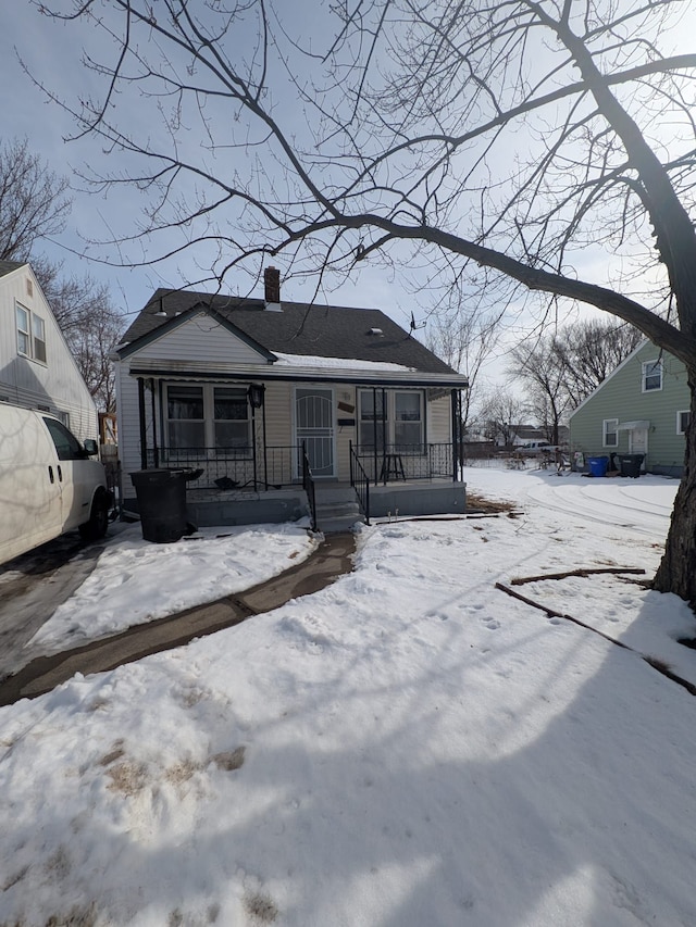 view of front facade featuring covered porch and a chimney