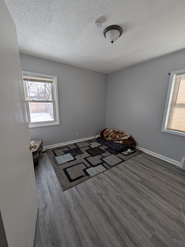 unfurnished bedroom featuring a textured ceiling, dark wood-type flooring, visible vents, and baseboards