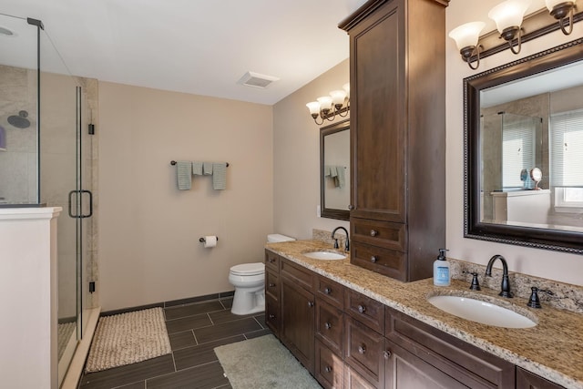 bathroom with double vanity, a shower stall, and a sink