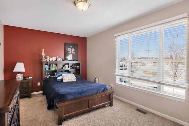 bedroom with light colored carpet, visible vents, and baseboards