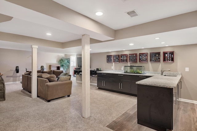 bar featuring baseboards, recessed lighting, a sink, and wet bar