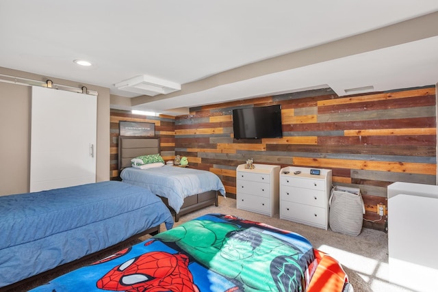 bedroom with recessed lighting, light carpet, wooden walls, and a barn door