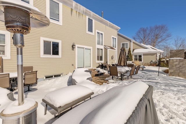 view of snow covered back of property