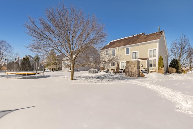 snow covered property featuring a trampoline and a residential view