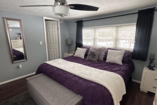 bedroom featuring dark wood finished floors, a textured ceiling, baseboards, and ceiling fan