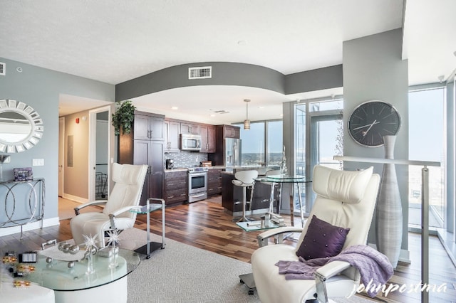 living room featuring baseboards, visible vents, and dark wood finished floors