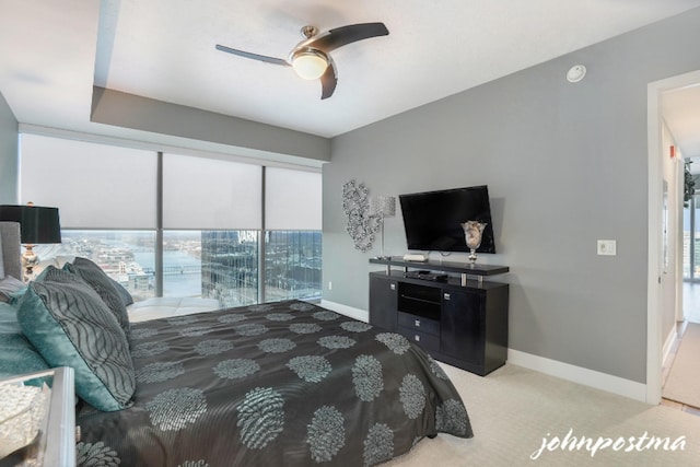 bedroom with light carpet, ceiling fan, and baseboards