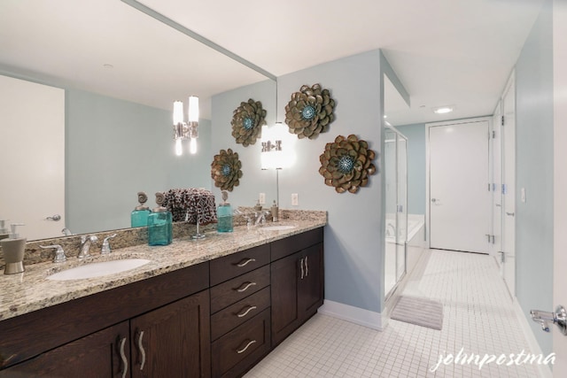 bathroom featuring double vanity, a sink, a shower stall, and tile patterned floors