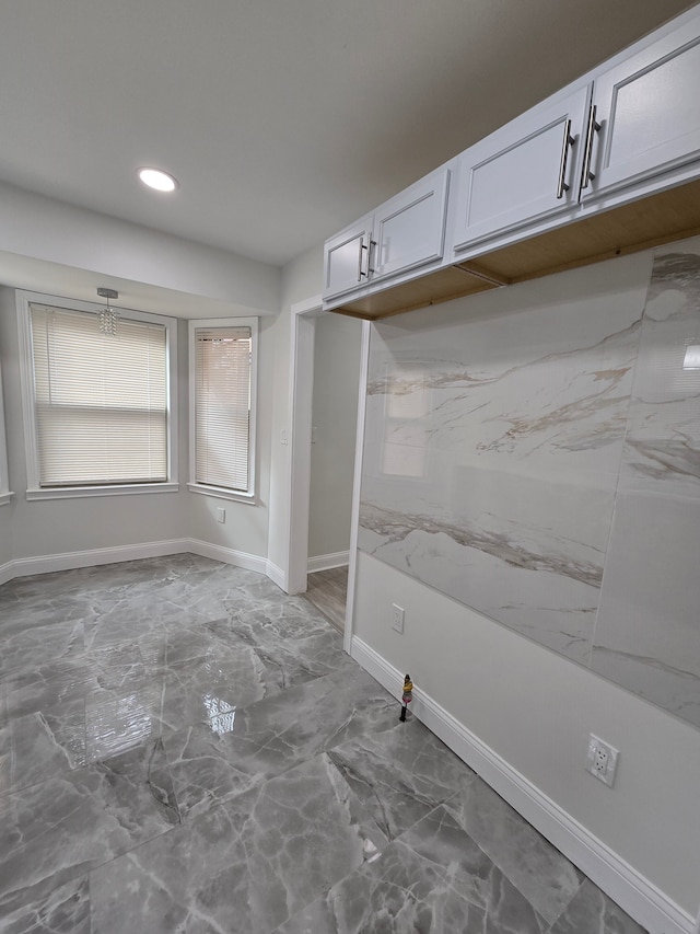 mudroom featuring recessed lighting, marble finish floor, and baseboards