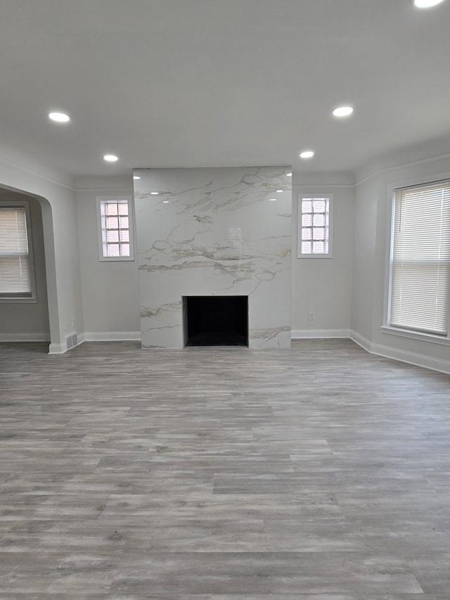 unfurnished living room with plenty of natural light, a fireplace, baseboards, and recessed lighting