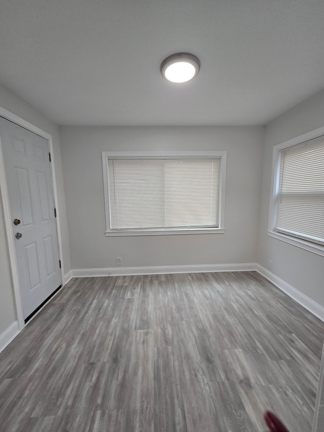 unfurnished room featuring baseboards and wood finished floors