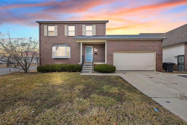 traditional-style home with brick siding, concrete driveway, an attached garage, a front yard, and fence