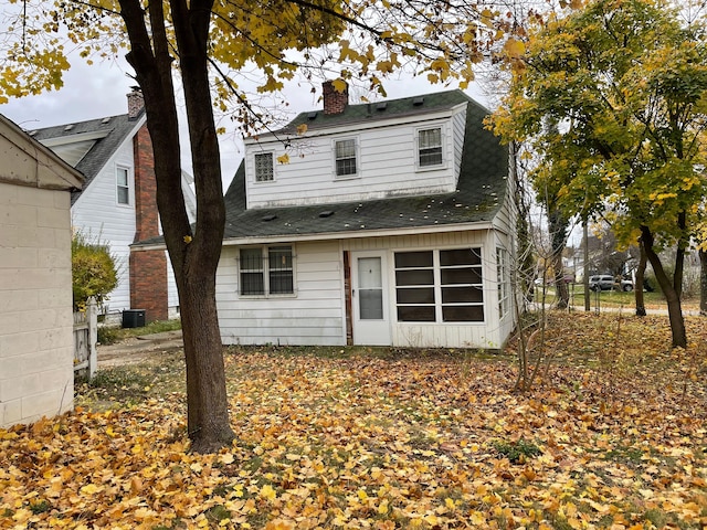 back of property featuring central air condition unit, a chimney, fence, and roof with shingles