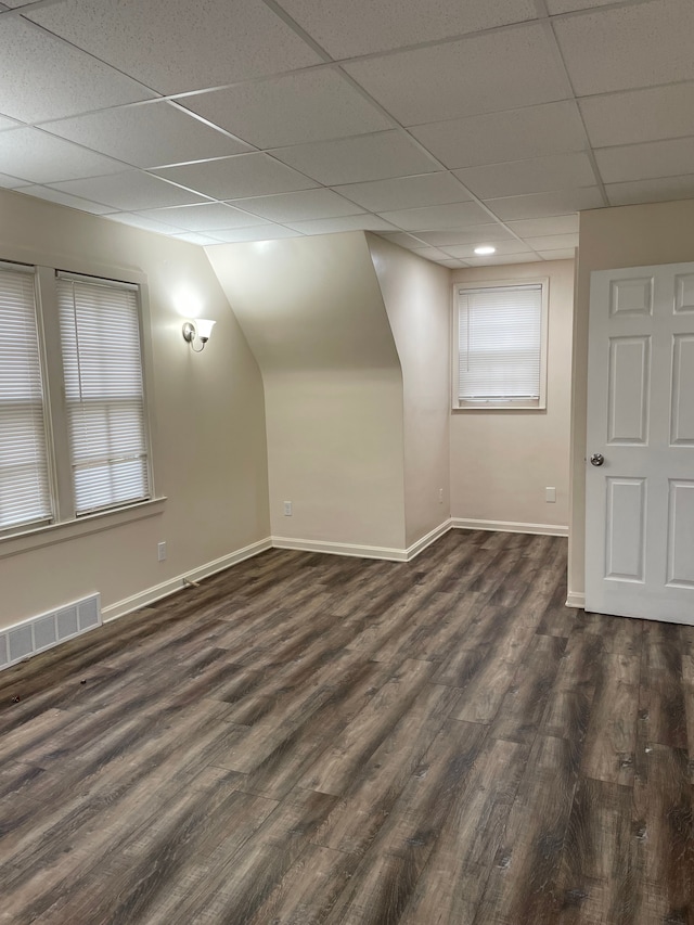 additional living space with dark wood finished floors, visible vents, and baseboards