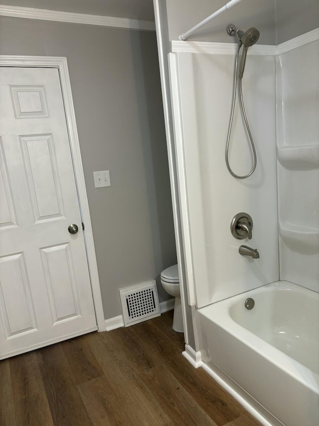 bathroom with crown molding, shower / bathtub combination, visible vents, toilet, and wood finished floors