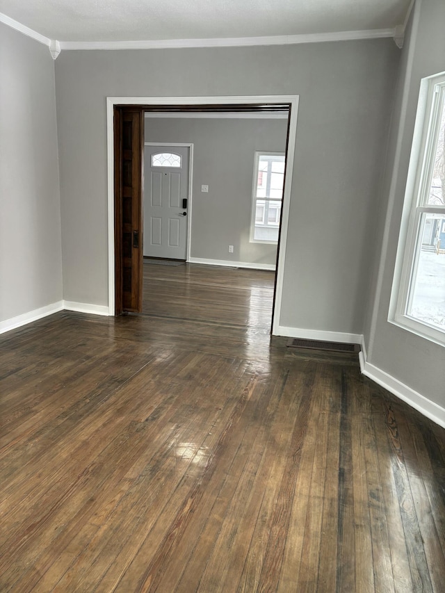 interior space with dark wood-style floors, baseboards, and crown molding