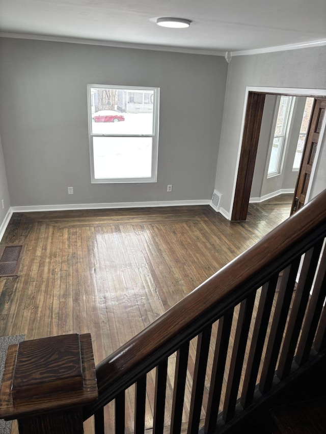 unfurnished room with crown molding, visible vents, and dark wood-style flooring