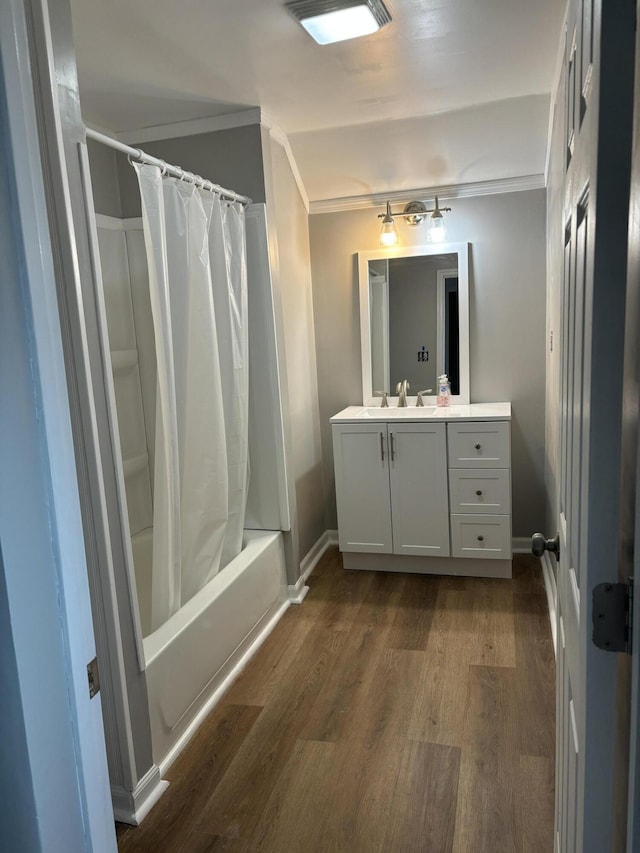 full bathroom featuring shower / bath combination with curtain, ornamental molding, vanity, wood finished floors, and baseboards