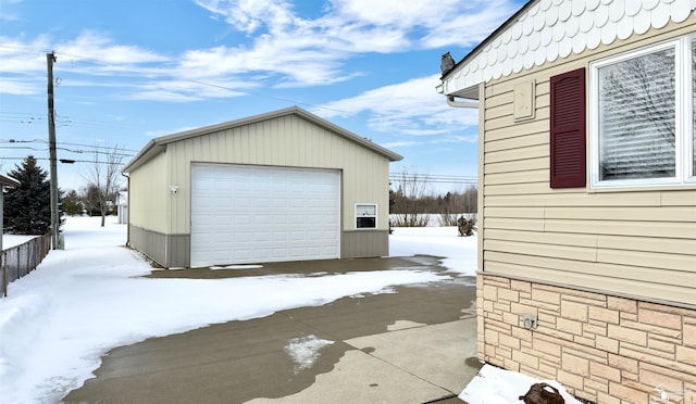 snow covered garage featuring a detached garage