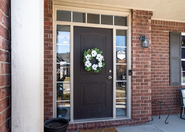 view of exterior entry with brick siding