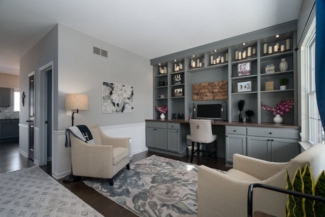 office space with dark wood-style flooring, built in study area, visible vents, and baseboards