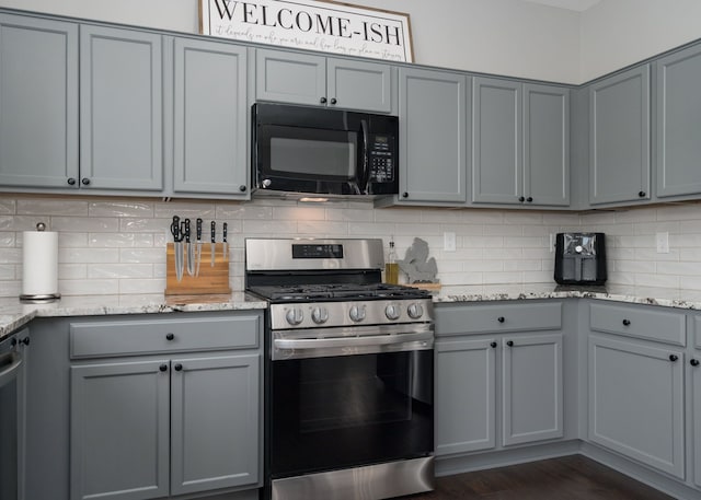 kitchen featuring black microwave, gray cabinetry, and gas range