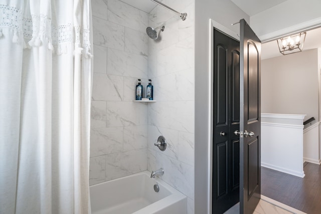 bathroom with shower / tub combo with curtain and wood finished floors