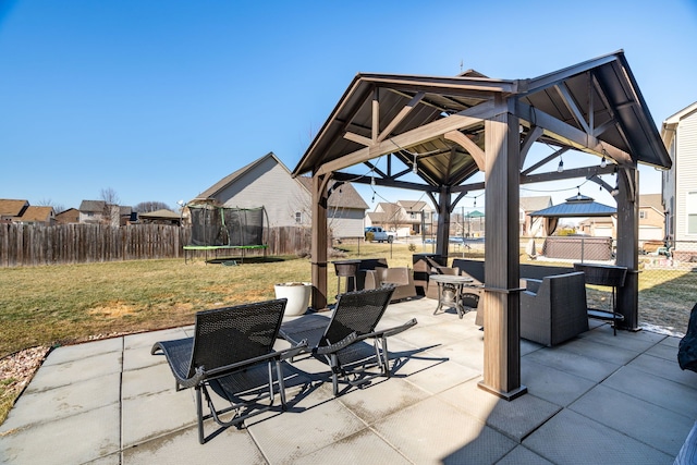 view of patio / terrace featuring a trampoline, fence, and a gazebo