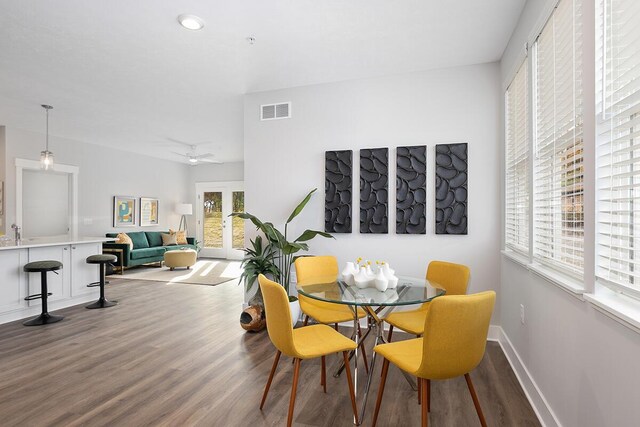 dining room featuring french doors, wood finished floors, visible vents, and baseboards