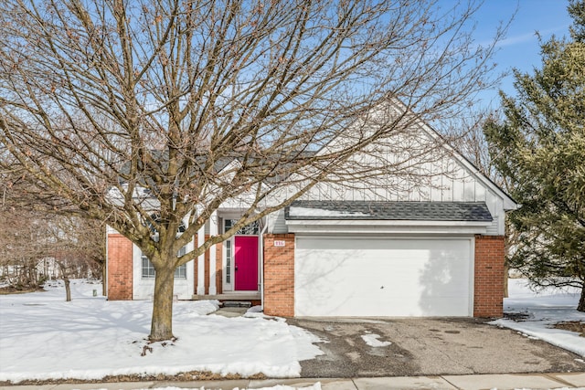 view of front of property featuring a shingled roof, brick siding, driveway, and an attached garage