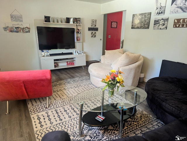 living area with baseboards and wood finished floors