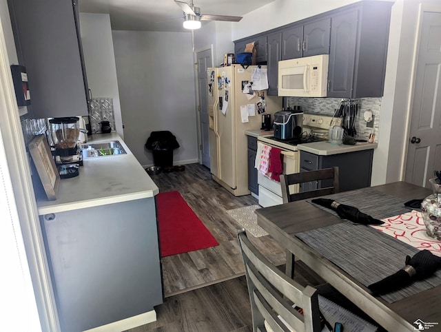 kitchen with tasteful backsplash, white appliances, light countertops, and dark wood-style flooring