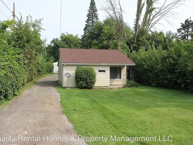 view of outdoor structure featuring aphalt driveway and an outbuilding