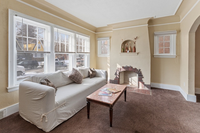 carpeted living room with baseboards and arched walkways