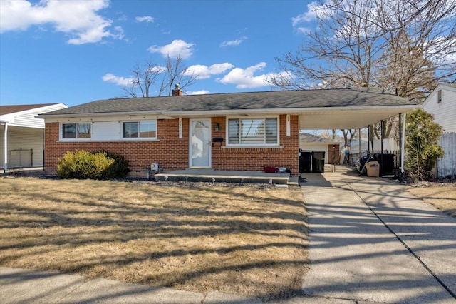 view of front of house with an attached carport, brick siding, and driveway