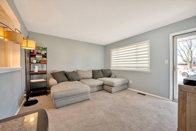 carpeted living area with baseboards and visible vents