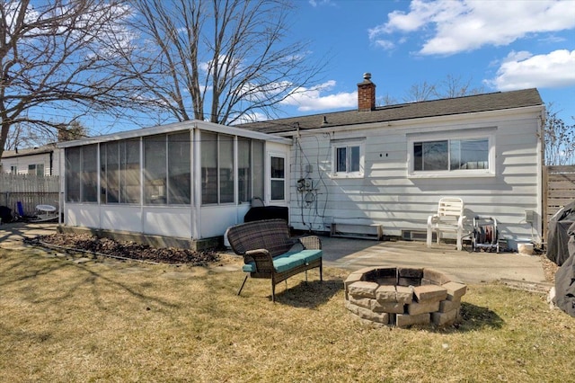 back of house featuring a yard, a patio, a chimney, and a sunroom