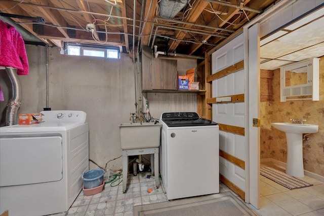 clothes washing area with laundry area, washer and dryer, and a sink