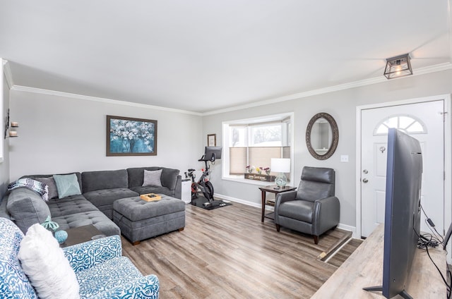 living room with crown molding, baseboards, and wood finished floors