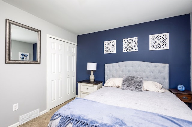 bedroom with carpet, visible vents, a closet, and baseboards